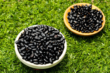 Fresh Black Beans in Wooden Bowls on Green Grass - Healthy Organic Legumes and Natural Nutrition Ingredients