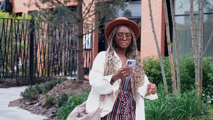 A woman uses a city map and geolocation on her smartphone to navigate the area while traveling.