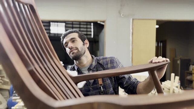 Craftsman's Pride: A focused craftsman examines a beautifully crafted wooden chair in his workshop, embodying dedication to his trade and the artistry of woodworking.