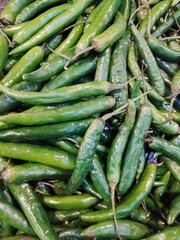 Close-up of fresh green chili peppers with natural texture and vibrant color. Perfect food background or ingredient image representing spice, cooking, and healthy organic vegetables.