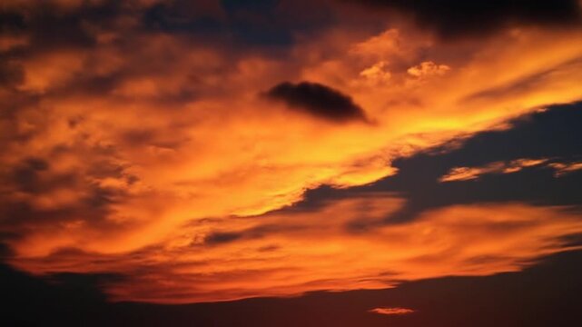A stunning sunset casts a vibrant glow through the clouds, creating a breathtaking scene in the sky that's perfect for nature lovers and photographers.
