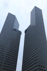 Tall modern skyscrapers with glass windows rising into the sky, showcasing contemporary urban architecture and city skyline.