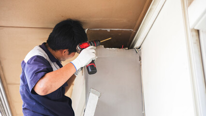 Technician Installing New Air Conditioner Unit, Construction Worker Drilling Hole in Ceiling, HVAC Technician Installing a Vent or Duct, Man Using a Power Drill for Home Renovation