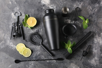 Modern bartender kit and cocktail ingredients on grey grunge background, closeup