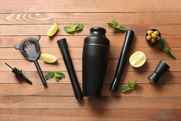 Composition with different bartender utensils and cocktail ingredients on wooden background