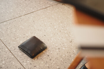Wallet dropped on the floor in a busy cafe setting