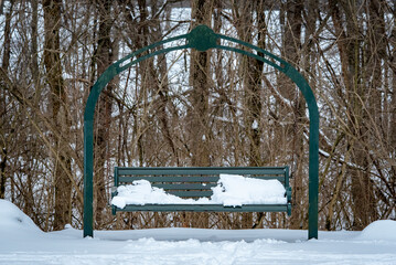 Snow covered park swing