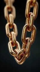Obraz premium Heavy golden chain links close-up showcasing texture and shine with a dark backdrop