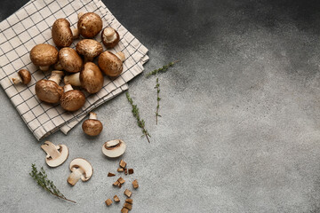 Composition with napkin and raw champignon mushrooms on grunge background