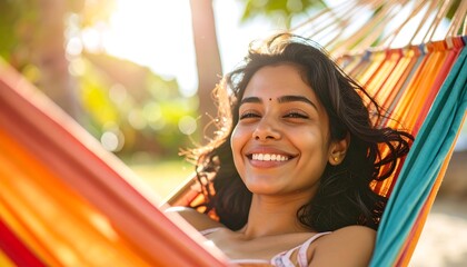Smiling woman relaxing in bright hammock with sunlit trees in background