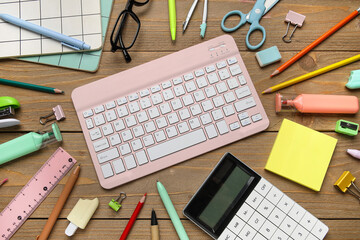 Composition with computer keyboard, eyeglasses and school supplies on wooden background, closeup