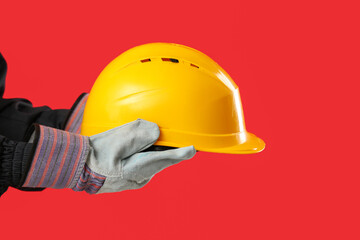 Worker with hardhat on red background, closeup
