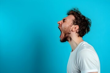 Side view, profile photo of a man shouting with his mouth wide open, isolated on a blue background. Concept with copy space.