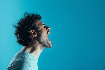 Side view, profile photo of a man shouting with his mouth wide open, isolated on a blue background. Concept with copy space.