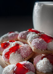 Marshmallow cookies with coconut flakes and strawberry jam on top with a glass of cold milk on the side, foods high in sugar and carbohydrates side view macro photography