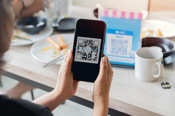 Selective focus of tourist woman scanning QR Code for contactless payment