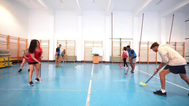 Floorball players training and practicing in a gym