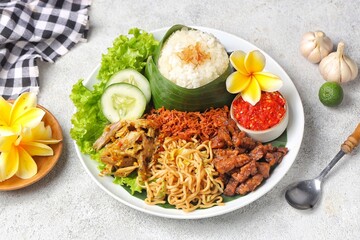 Nasi jinggo is a typical Balinese dish consisting of small portions of white rice wrapped in banana leaves, usually accompanied by side dishes such as shredded chicken, fried noodles, serundeng and ch