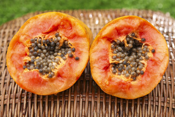 Fresh Hainan Red Papaya Heart-Shaped Halves with Seeds on Bamboo Mat