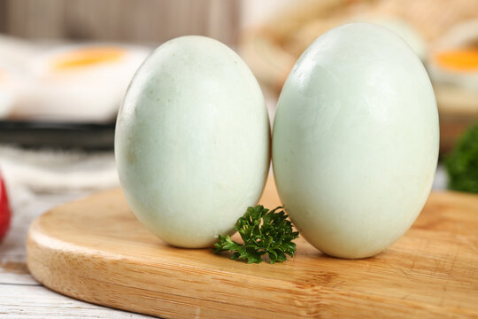 Fresh Raw Green-Shelled Farm Eggs with Clear Whites and Golden Yolks on Wooden Board