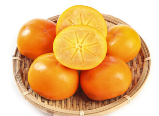 Fresh Persimmons in Wicker Basket on White Background with Halved Fruit Showing Interior