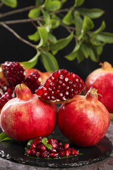 Fresh Ripe Pomegranates with Red Arils on Dark Slate Display