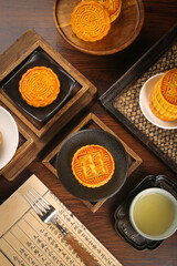 Traditional Chinese Mooncakes with Tea for Mid-Autumn Festival Celebration on Wooden Table