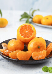 Fresh Seedless Satsumas from Guangxi Sihui China - Sweet Citrus Oranges on Dark Plate with Peeled Segments