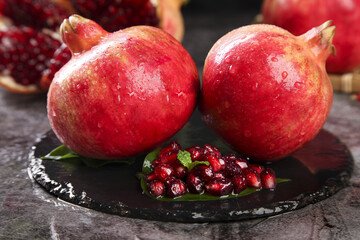 Fresh Tunisian Pomegranates with Ruby Red Seeds on Black Slate - Healthy Superfruit Display