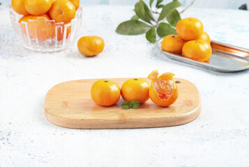 Fresh Small Tangerines from Guangxi China on Wooden Board with Peeled Segments