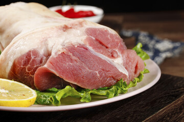 Fresh Raw Pork Cuts with Elbow Joint and Sliced Meat on Plate Ready for Cooking Preparation