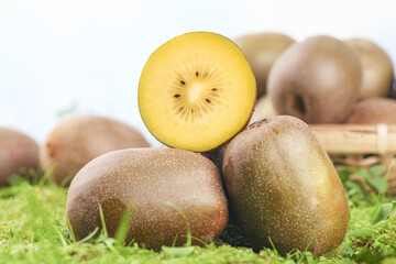 Fresh Yellow Kiwifruit with Heart Pattern Slice on Green Meadow Background