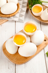Fresh Cracked Eggs with Golden Yolks on Wooden Cutting Board Kitchen Preparation
