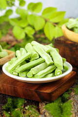 Fresh Green Beans in Bowl on Wooden Board with Herbs - Healthy Organic Vegetable Ingredient