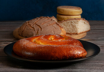Traditional Mexican sweet bread made in the state of Oaxaca, on a rustic wooden table with a blue background