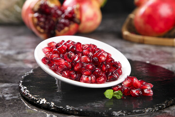 Fresh Red Pomegranate Seeds in White Bowl on Black Slate - Premium Quality Ruby Arils