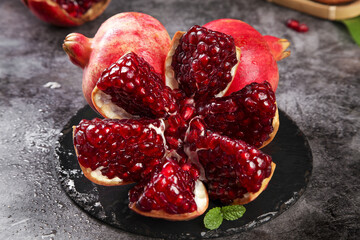 Fresh Pomegranate with Red Seeds and Soft Flesh Display on Black Slate
