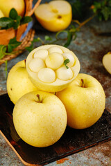 Fresh Golden Apples with Artistic Carved Presentation on Rustic Wooden Board