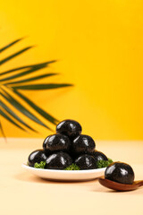 Nutritious Black Sesame Seed Balls on Plate with Palm Leaf Shadow - Healthy Diet Snack Food Closeup