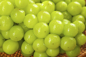 Fresh Green Grapes with Water Droplets in Wicker Basket Display