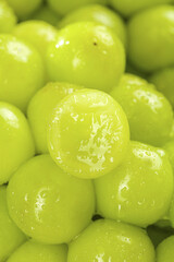 Fresh Green Grapes with Water Drops and Cut Half Showing Interior Detail