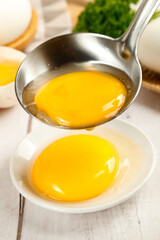 Fresh Large Poultry Eggs Just Laid with Bright Yolks in Kitchen Bowl and Ladle for Cooking