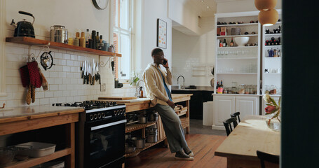 Listen, phone call and happy black man in kitchen for chat, gossip or communication with contact. African person, smile and conversation with mobile for news, story or feedback for connection in home