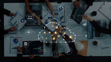 A diverse group of professionals collaborates over digital data and cloud technology, analyzing reports and charts in a modern office setting, enhancing productivity. Raster - Powered by Adobe