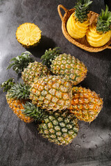 Fresh Pineapples with Sweet Golden Pulp and Slices on Dark Stone Surface