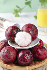 Fresh Yunnan Mangosteen Tropical Fruit with White Flesh Segments in Bamboo Basket