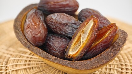 Dried dates fruits in wooden bowl.