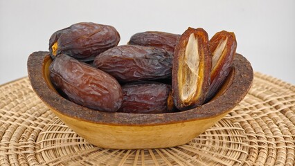 Dried dates fruits in wooden bowl.