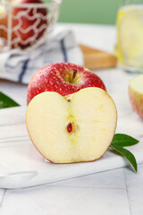 Fresh Red Apple Half with Water Droplets and Heart-Shaped Core on White Wooden Background