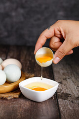 Fresh Free Range Eggs Being Cracked in Rustic Country Farmhouse Kitchen Setting